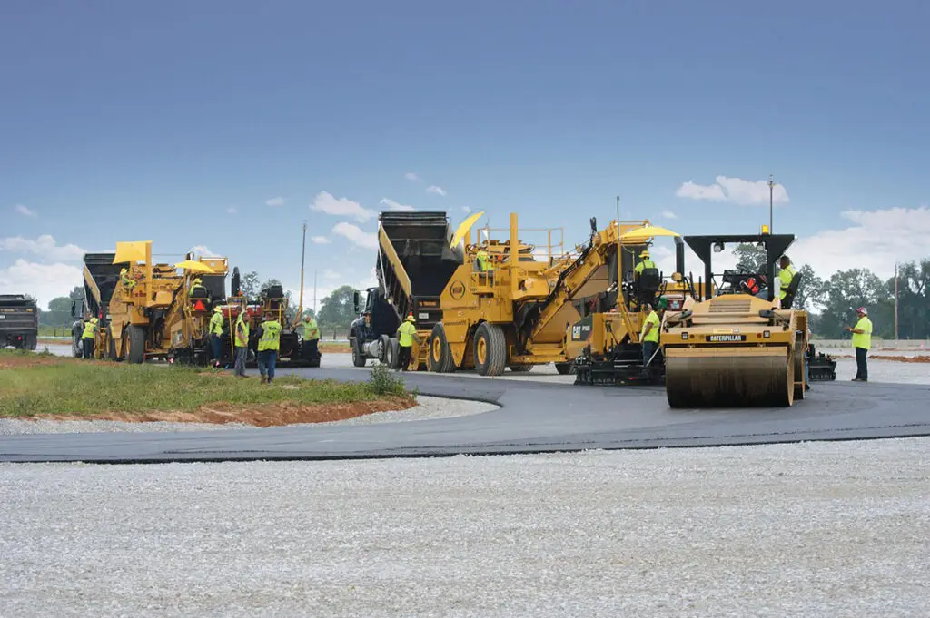 Equipo de maquinaria amarilla Caterpillar en un proyecto de pavimentación.