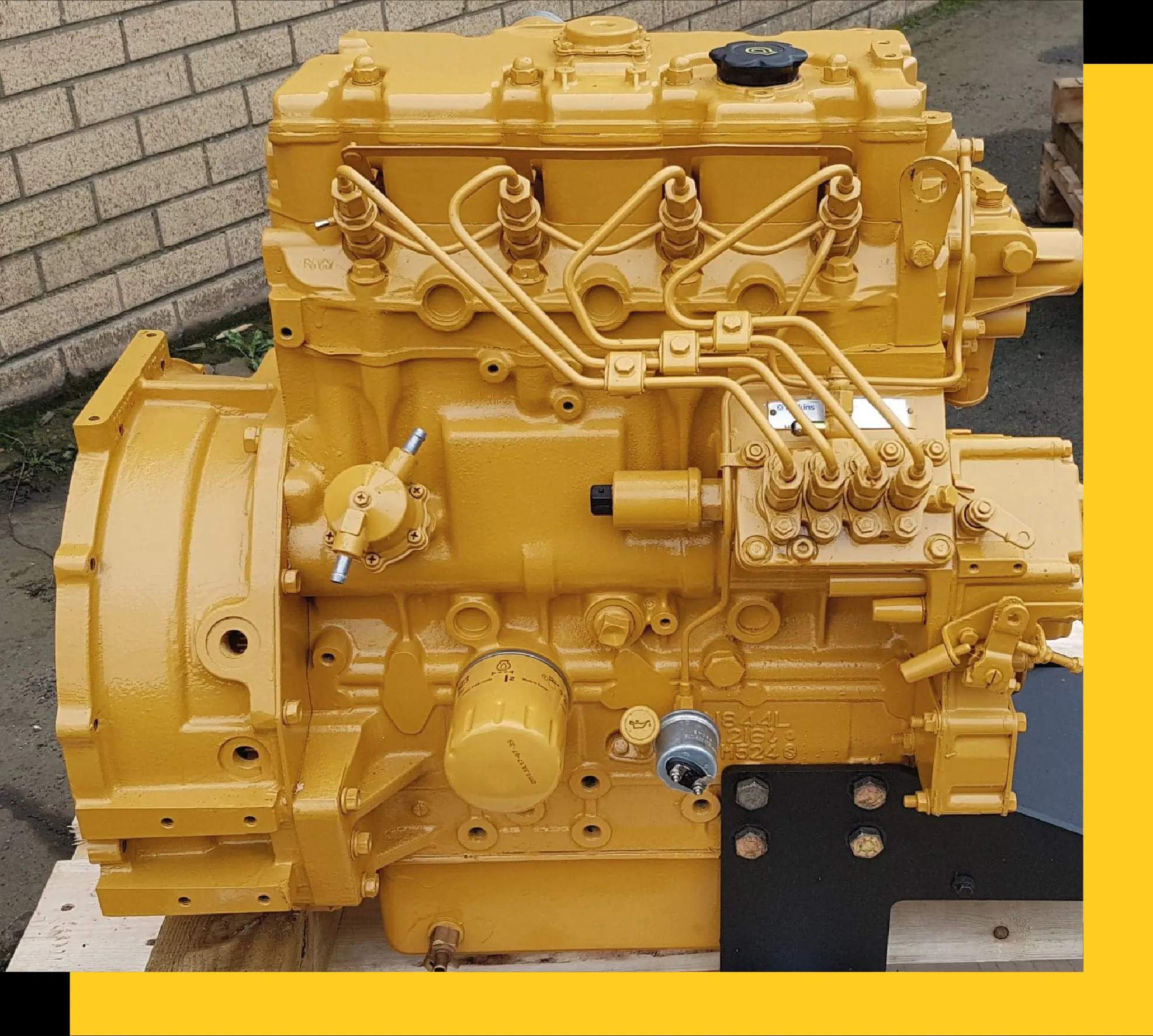 Motor Caterpillar reconstruido y pintado de amarillo, sobre plataforma de madera.